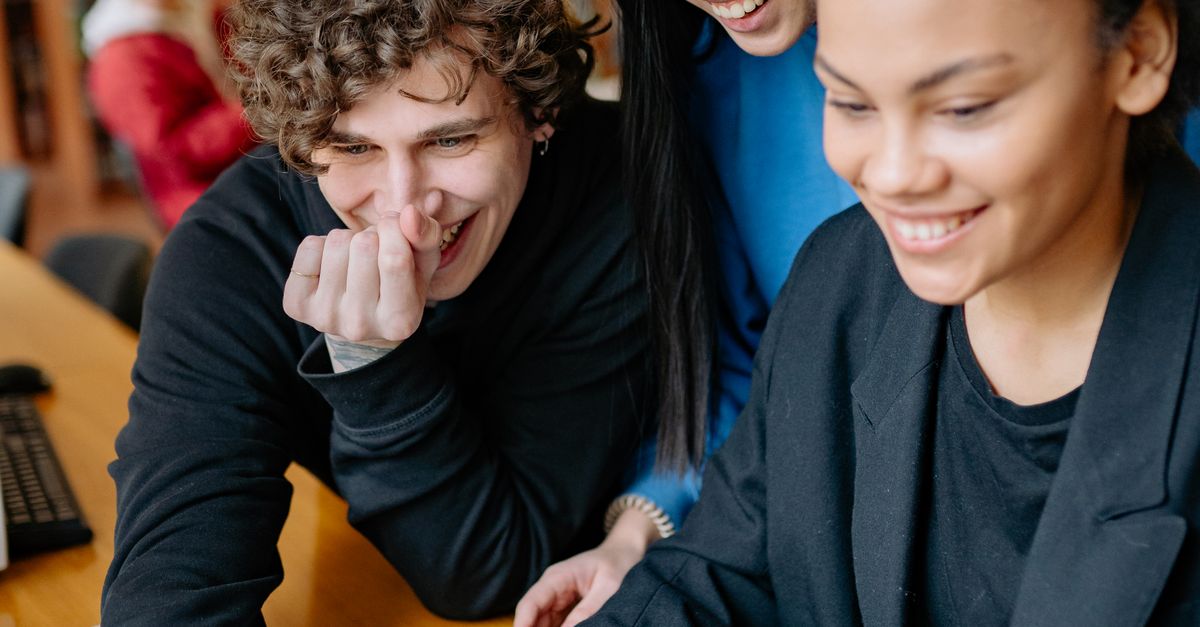 Students sharing a smile while working at a laptop